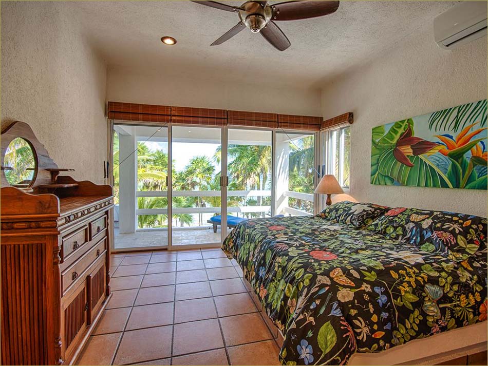 Master bedroom upstairs features a king sized bed, open balcony and private bathroom.